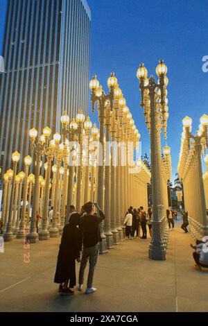 Un gruppo di individui urbani riuniti intorno a un semaforo della città Foto Stock