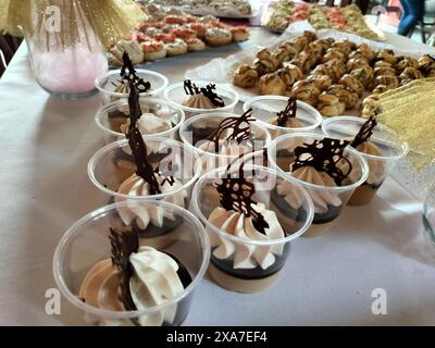 Dessert e portacandele disposti in portabicchieri per l'esposizione Foto Stock