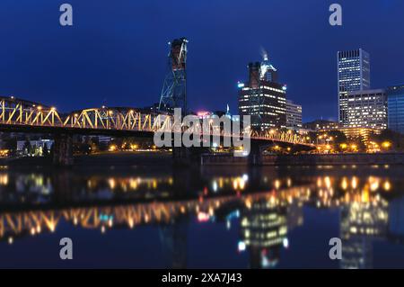 Una scena notturna di un ponte sull'acqua tra gli edifici della città Foto Stock