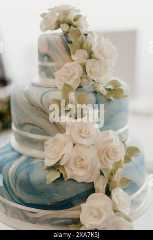 Torta nuziale a tre piani dal design elegante e decorata con motivi floreali Foto Stock