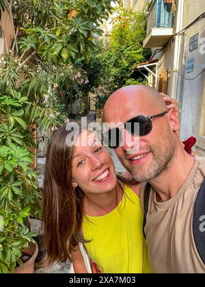 Un uomo barbuto sta accanto a una donna in cima gialla in Grecia Foto Stock