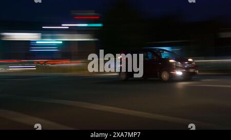 Mostrare le auto e il traffico di notte, utilizzando la panoramica della telecamera per mostrare il movimento dell'auto con le piste leggere. Ad Auckland, nuova Zelanda. Foto Stock