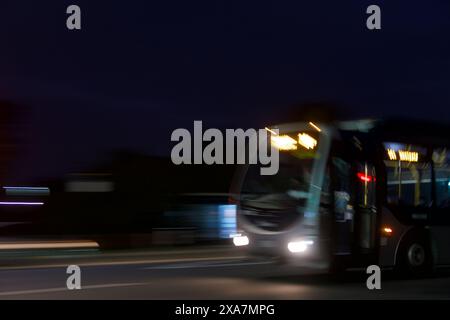 Mostrare le auto e il traffico di notte, utilizzando la panoramica della telecamera per mostrare il movimento dell'auto con le piste leggere. Ad Auckland, nuova Zelanda. Foto Stock