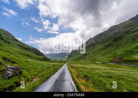 Una strada tortuosa attraversa una valle di montagna Foto Stock