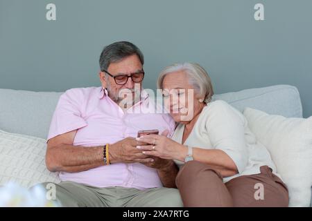 La coppia anziana controlla il cellulare insieme Foto Stock