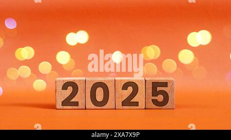 Pianificazione aziendale nel 2025. Cubi di legno con numeri 2025 su tavola con sfondo bokeh Foto Stock