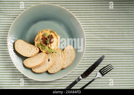 Vista dall'alto dell'hummus di ceci servito su un piatto con pezzi di pane. Cibo vegetariano e mangiare sano Foto Stock