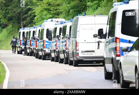 Bad Teinach Zavelstein, Germania. 5 giugno 2024. I veicoli della polizia sono parcheggiati su una strada di fronte a un albergo in un'area boscosa. Un complesso edilizio e una proprietà sono perquisiti in connessione con un raid contro sospetti sostenitori di un gruppo Reichsbürger. Crediti: Bernd Weißbrod/dpa/Alamy Live News Foto Stock