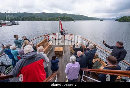 Il solitario Richard Cowie, dei massoni della Cumbria, gioca sul ponte di una delle crociere sul lago Windermere, i tradizionali piroscafi a Bowness-on-Windermere, Lake District, durante un evento commemorativo del D-Day. Il Pifferaio ha giocato in varie località della Cumbria meridionale negli ultimi 8 giorni, per onorare il pifferaio del D-Day Bill Millin che ha giocato sulle spiagge della Normandia il D-Day per confondere le truppe nemiche e aumentare il morale delle truppe alleate. Data foto: Mercoledì 5 giugno 2024. Foto Stock