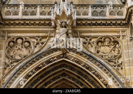 Un primo piano dell'intricata muratura in pietra sopra l'ingresso della Cappella reale di Dreux, Francia, con un angelo con le ali allungate e due fichi Foto Stock