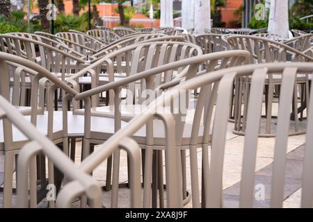 Una fila di sedie è vuota in un ristorante. Le sedie sono tutte dello stesso colore e disposte in una fila ordinata. Le sedie sono rivolte nella stessa direzione, Foto Stock