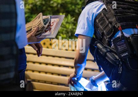 Hong Kong, Cina. 4 giugno 2024. Una donna ha la sua borsa e gli effetti personali perquisiti dalla polizia a Victoria Park, Causeway Bay. Stava leggendo "maggio 35", un'opera scritta sul massacro di Tienanmen. La polizia era in piena forza sul sito di una cerimonia di commemorazione per coloro che hanno perso la vita durante la repressione del governo cinese in piazza Tiananmen il 4 giugno 1989. La polizia ha arrestato, perquisito e rimosso diverse persone che stavano tentando di memorizzare l'evento. (Foto di Ben Marans/SOPA Images/Sipa USA) credito: SIPA USA/Alamy Live News Foto Stock