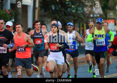 Babylon, New York, USA - 22 ottobre 2023: Molti corridori che corrono una mezza maratona o una maratona completa o 10K sulla strada principale di Babylon New York. Foto Stock