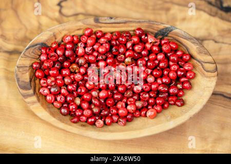 peperoncino, aroeira, peperone, peperoncino, wilelaiki, wililaiki (spec. Schinus), pepe rosso su un piatto di legno Foto Stock