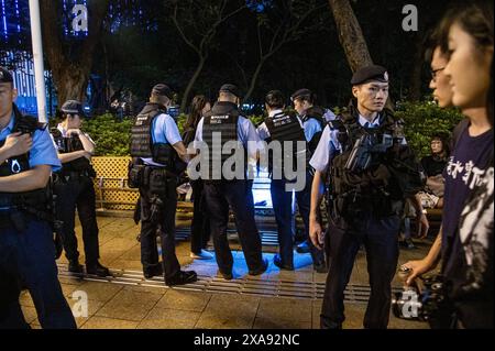 Hong Kong, Cina. 4 giugno 2024. Una donna ha la sua borsa e gli effetti personali perquisiti dalla polizia a Victoria Park, Causeway Bay. Stava leggendo "maggio 35", un'opera scritta sul massacro di Tienanmen. La polizia era in piena forza sul sito di una cerimonia di commemorazione per coloro che hanno perso la vita durante la repressione del governo cinese in piazza Tiananmen il 4 giugno 1989. La polizia ha arrestato, perquisito e rimosso diverse persone che stavano tentando di memorizzare l'evento. Credito: SOPA Images Limited/Alamy Live News Foto Stock