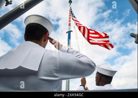 Oahu, Hawaii - 02 agosto 2016: Marinai della US Navy che battono la bandiera americana su un palo e saluta Foto Stock