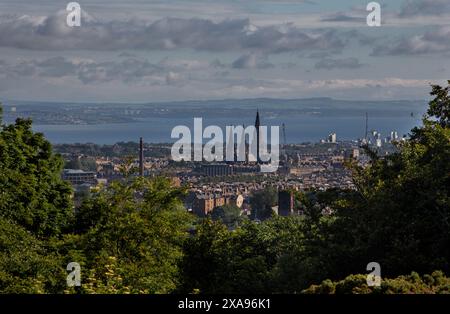 Edimburgo, Scozia; 06-20-2020: Skyline della città e cattedrale di Santa Maria, con alberi verdi in primo piano e Forth e Fife sullo sfondo. Foto Stock