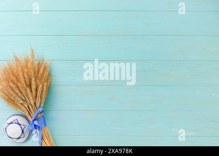 Storia ebraica Shavuot. Bouquet maturo di grano con nastro blu con bandiera israeliana e sfondi. Simboli del concetto Shavuot festivo ebraico. Indietro Foto Stock