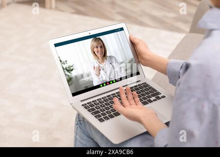 Consultazione medica online. Donna che ha una video chat con il medico via portatile a casa, primo piano Foto Stock