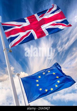 BREXIT BANDIERE del Regno Unito e dell'UE CHE VOLANO NUVOLE CONCEPT britannico Union Jack Flag del Regno Unito in alto sopra la bandiera europea dell'UE in brezza nelle giornate di sole con un cielo e bandiere spettacolari Foto Stock