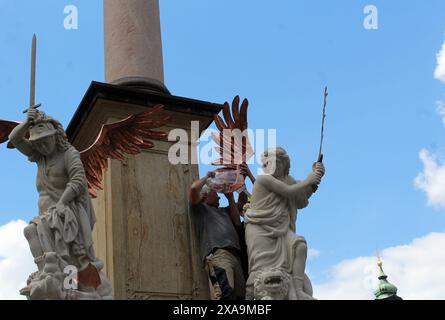 Installazione di statue imitanti degli Angeli del XVII secolo su una colonna barocca della Vergine Maria dello scultore Petr Vana sulla Piazza della città Vecchia di Praga Foto Stock