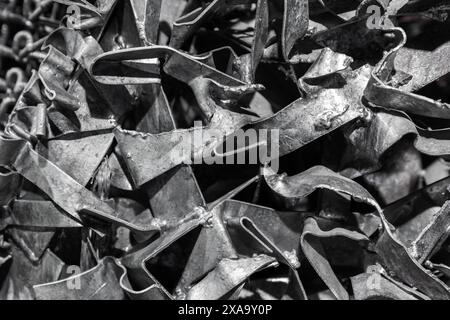 Foto di sfondo industriale astratto con un muro fatto di caotici frammenti di acciaio grezzo saldato Foto Stock