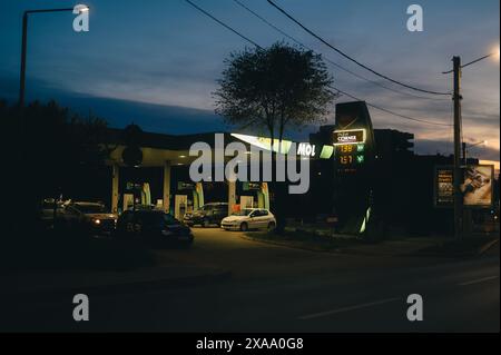 Una notte intensa in un distributore di benzina in strada con il traffico che passa Foto Stock