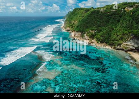 Splendida costa con oceano turchese e scogliere verdi a Bali. Vista aerea Foto Stock