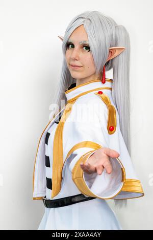 Una cosplayer donna vestita da elfo con capelli bianchi su sfondo bianco Foto Stock