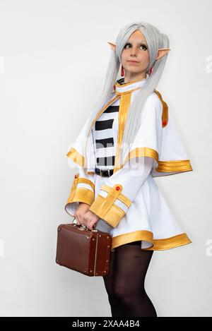 Una cosplayer donna vestita da elfo con capelli bianchi su sfondo bianco Foto Stock