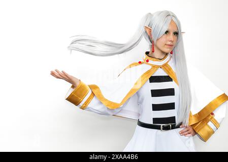 Una cosplayer donna vestita da elfo con capelli bianchi su sfondo bianco Foto Stock