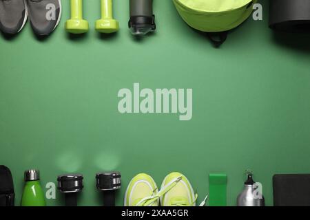 Telaio realizzato con diverse attrezzature sportive su sfondo verde, piatto. Spazio per il testo Foto Stock