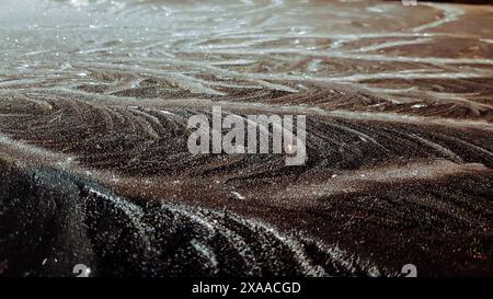 Un primo piano di rocce umide sulla spiaggia di notte Foto Stock