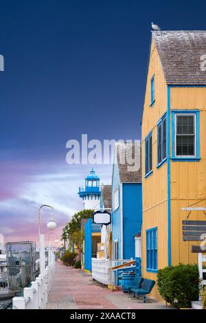 Una casa gialla con finestre blu e finestre multiple sulla sua facciata Foto Stock