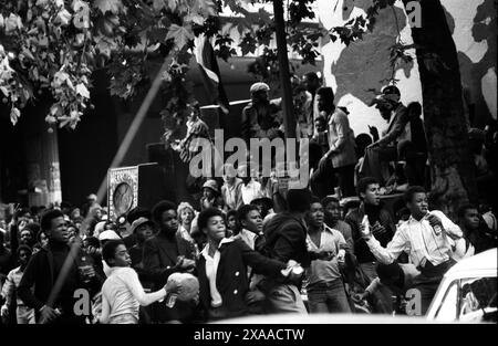 Rivolte di Carnevale di Notting Hill. La polizia viene attaccata da giovani britannici di colore che lanciano pietre e missili. Disordini urbani nel centro della città. Agosto giorni festivi lunedì 1976. Notting Hill, Londra, Inghilterra anni '1970 UK HOMER SYKES Foto Stock