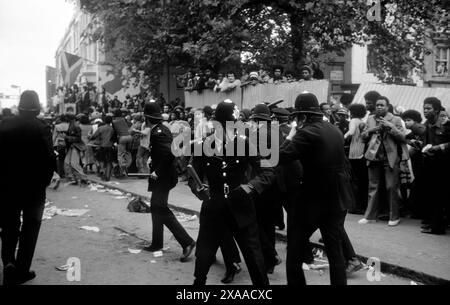 Nel Regno Unito degli anni '1970, violenze urbane, disordini, manganelli della polizia britannica, si riuniscono per l'autoprotezione. Non hanno scudi o indumenti protettivi. Notting Hill carnevale Riot Londra, Inghilterra 30 agosto. 1976 HOMER SYKES Foto Stock