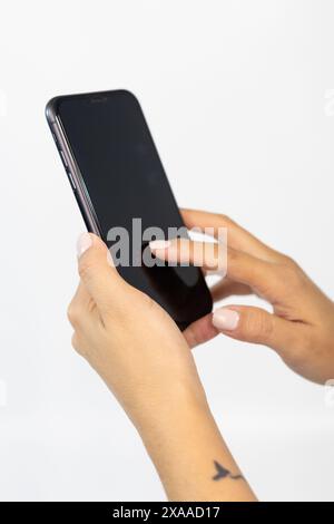 Mani che tengono uno smartphone in uno scatto dettagliato Foto Stock