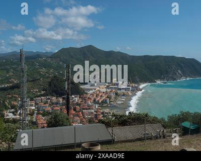 Vista aerea panoramica sul villaggio di Riva Trigoso da Punta Manara, spiaggia di sabbia, case, cantiere navale e nella soleggiata giornata autunnale. Sestri Levante, Liguria, Italia Foto Stock