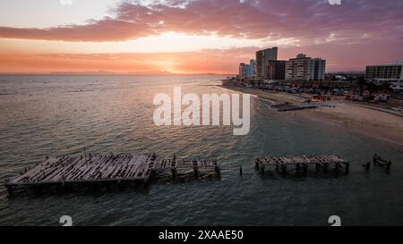 Un tramonto a Strand con il vecchio molo sagomato contro un cielo vibrante Foto Stock