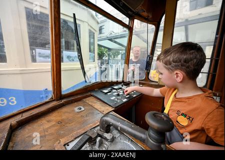 LEOPOLI, UCRAINA - 1 GIUGNO 2024 - Un ragazzo esplora il cruscotto di una delle vecchie tram durante una mostra in Piazza Dvirtseva che celebra i 130 anni di tram di Leopoli, Ucraina occidentale. Foto Stock