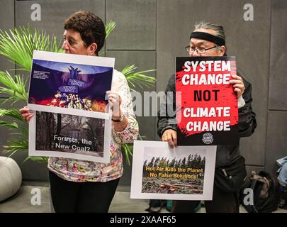 Bonn, Germania. 5 giugno 2024. Una donna con un cartello cambiamento di sistema, non cambiamento climatico come parte di una dimostrazione all'interno contro il cambiamento climatico, all'interno del World Conference Center nel campus delle Nazioni Unite di Bonn durante la prima settimana della conferenza SB60 sul cambiamento climatico. La finanza e la silvicoltura dei combustibili fossili sono elementi chiave durante le discussioni e i negoziati. Questo è il punto di partenza dei preparativi per l'evento COP29 che si terrà a Baku, Azerbaigian, nel novembre di quest'anno. (Credit Image: © Bianca Otero/ZUMA Press Wire) SOLO PER USO EDITORIALE! Non per USO commerciale! Foto Stock