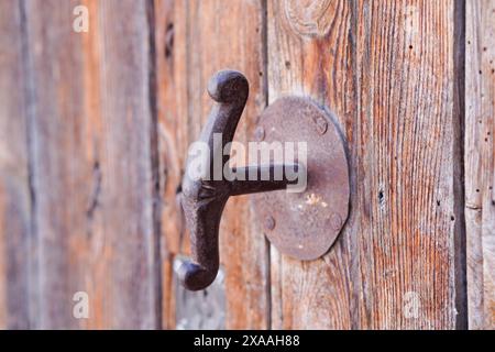 maniglia per porta in ferro anticato ruggine su porta in legno Foto Stock