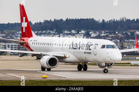 Un Embraer 190LR dai taxi della Helvetic Airways sulla pista all'Aeroporto di Zurigo, dove aspetta che decolli l'autorizzazione. Registrazione HB-JVX. (Z Foto Stock