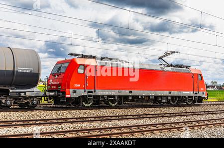 Hebertshausen, Germania, 10 aprile 2024: Una locomotiva elettrica RheinCargo DB Classe 185 tira un treno merci con autocisterne. (Foto di Jonas Philippe/di Foto Stock