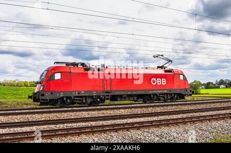 Hebertshausen, Germania, 10 aprile 2024: Una locomotiva Taurus delle Ferrovie federali austriache (ÖBB) prodotta dalla Siemens parte da Monaco verso Nur Foto Stock