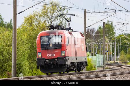 Hebertshausen, Germania, 10 aprile 2024: Una locomotiva Taurus delle Ferrovie federali austriache (ÖBB) prodotta dalla Siemens parte da Monaco verso Nur Foto Stock