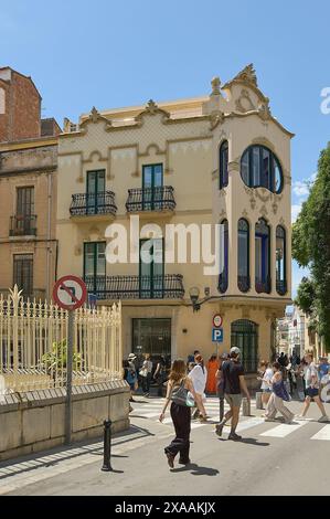 Sitges, Barcellona, Spagna - 5 giugno 2024: Un perfetto esempio del fascino architettonico di Sitges catturato dalla facciata dettagliata e dalla vita quotidiana Foto Stock