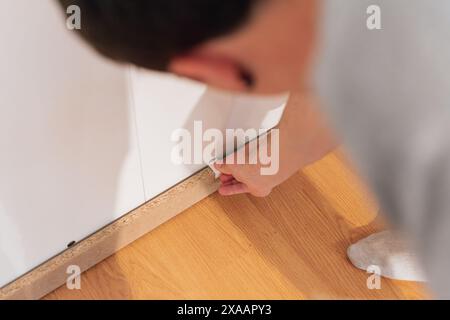 Un giovane che mette pezzi di un nuovo armadio in casa sua. Arredamento Foto Stock