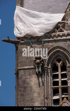 L'immagine è del paracadutista americano John Steele, che ha preso parte all'invasione alleata della Francia il 6 giugno 1944 noto come D-Day. Sfortunatamente Giovanni atterrò sul tetto della chiesa e fu appeso al parapetto della chiesa mentre la battaglia infuriava sotto di lui. Ferito alla fine fu catturato, ma in qualche modo riuscì a fuggire alle linee alleate. Foto Stock