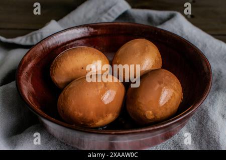 Vista ravvicinata delle uova in salsa di soia in una ciotola di legno: Uova sode marinate in salsa di soia speziata Foto Stock